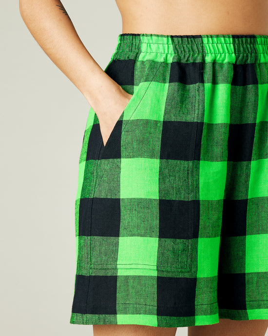 model wears green and black check ari shorts