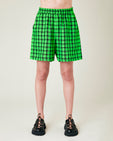 model wears green and black check ari shorts