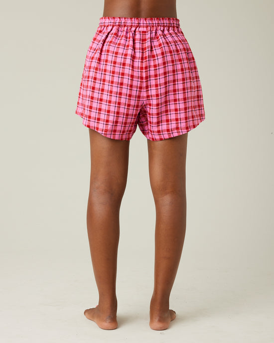 model wears pink and red check bed shorts