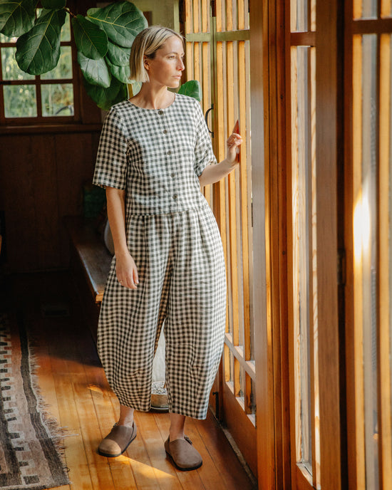 model wears daisy olive gingham linen trousers