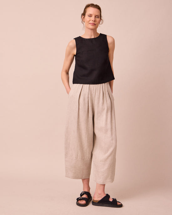 model wears bobbi natural linen trousers left
