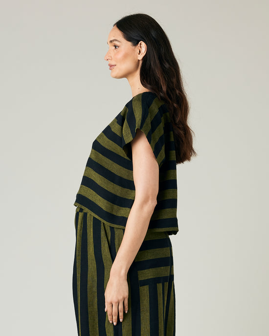 pregnant model wears olive and black stripe linen polly top