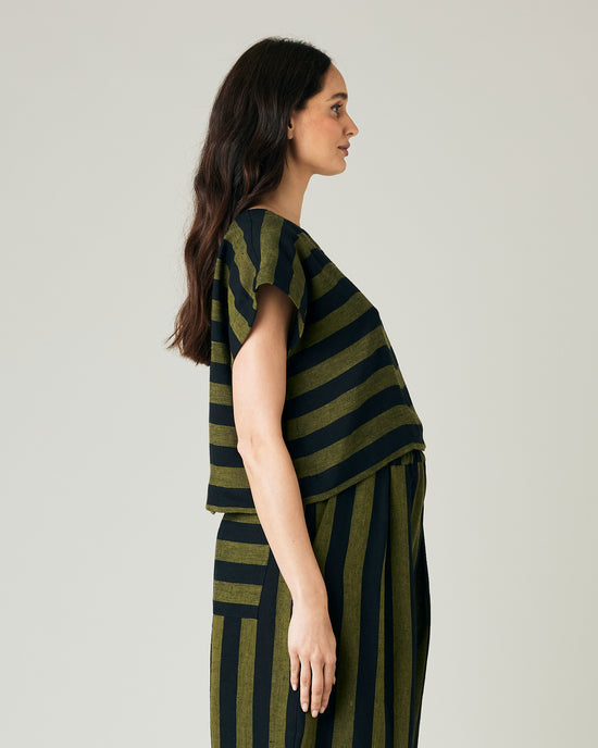 pregnant model wears olive and black stripe linen polly top