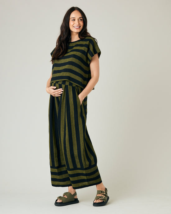 pregnant model wears olive and black stripe linen polly top