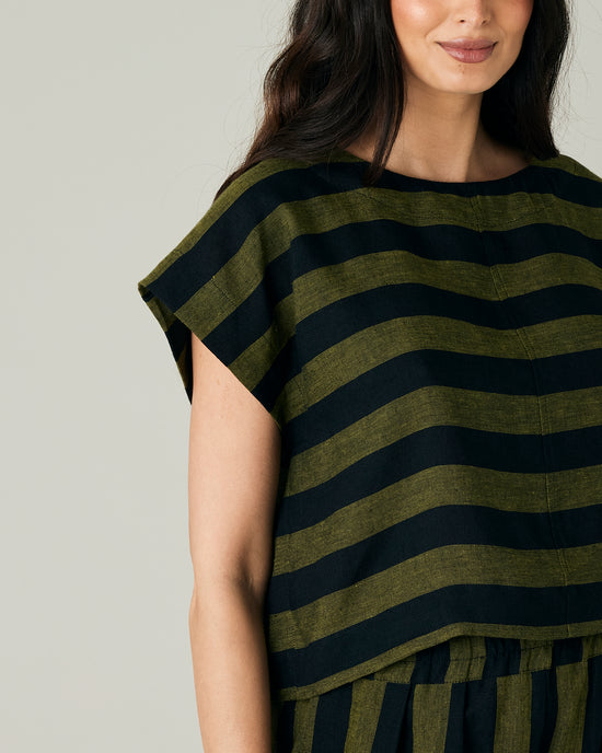 pregnant model wears olive and black stripe linen polly top