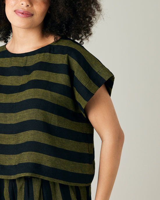 model wears olive and black stripe linen polly top