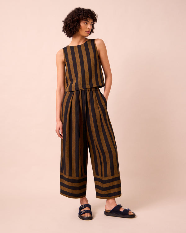 model wears bobbi rust stripe linen trousers left