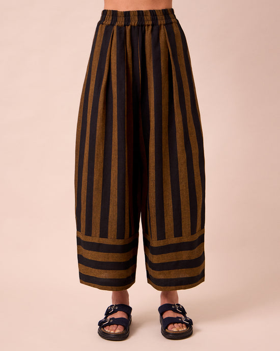 model wears bobbi rust stripe linen trousers front