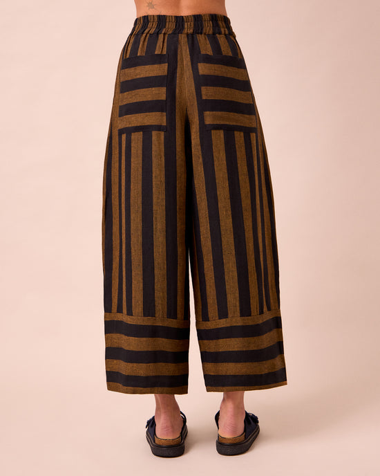 model wears bobbi rust stripe linen trousers back
