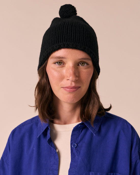 model wears black knitted bobble hat