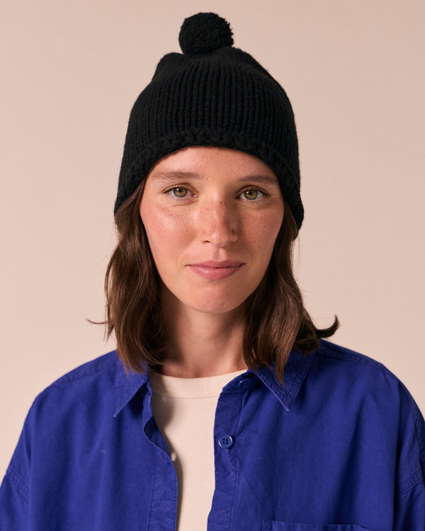 model wears black knitted bobble hat