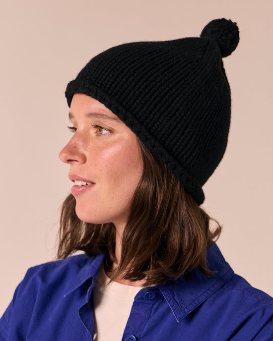 model wears black knitted bobble hat