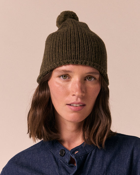 model wears the dark forest knitted bobble hat