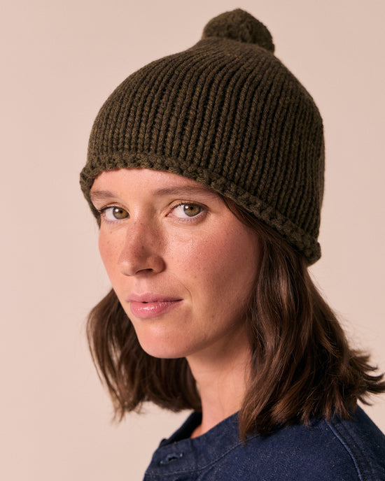 model wears the dark forest knitted bobble hat