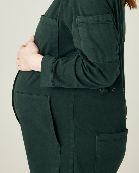 pregnant model wears bottle green coverall