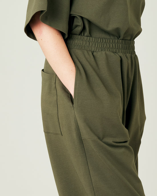 model wears olive huxley jersey trousers