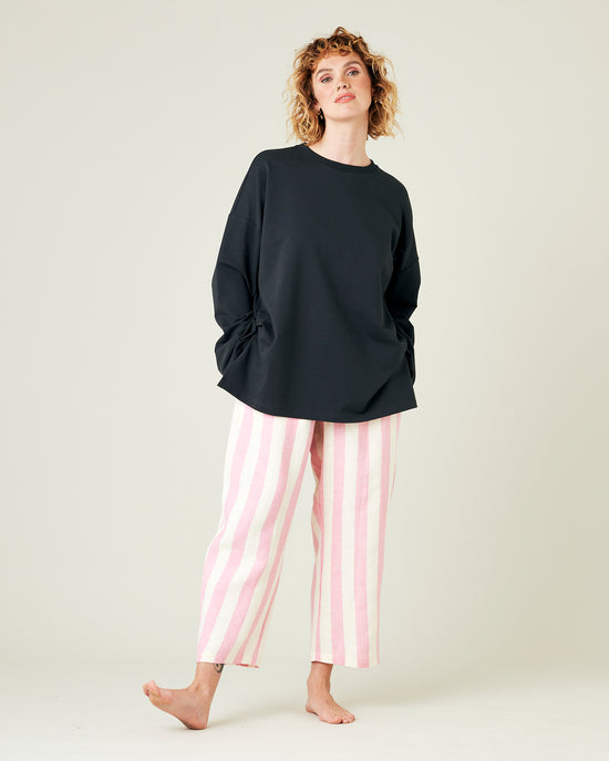 model wears pink and ecru stripe ultimate pj linen trousers