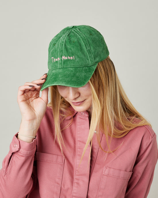 model wears green cord team mabel cap