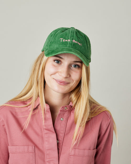 model wears green cord team mabel cap