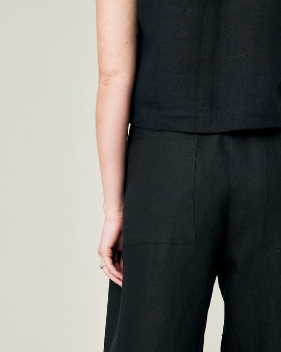 model wears black linen huxley trousers