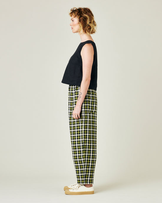 model wears olive black and ecru checked huxley trousers