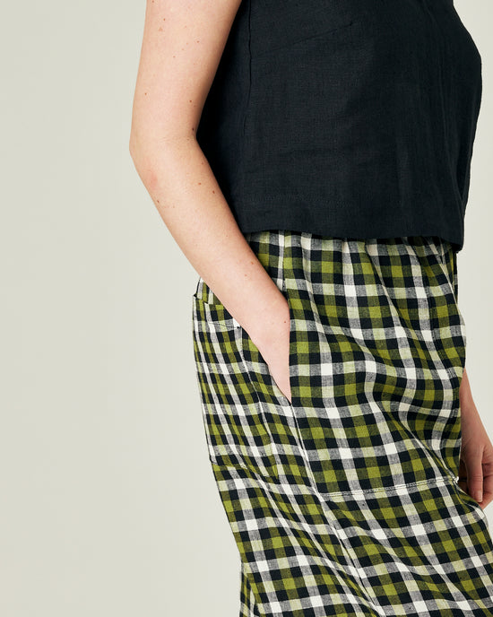 model wears olive black and ecru checked huxley trousers