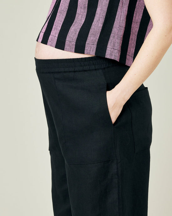 pregnant model wears black linen huxley trousers