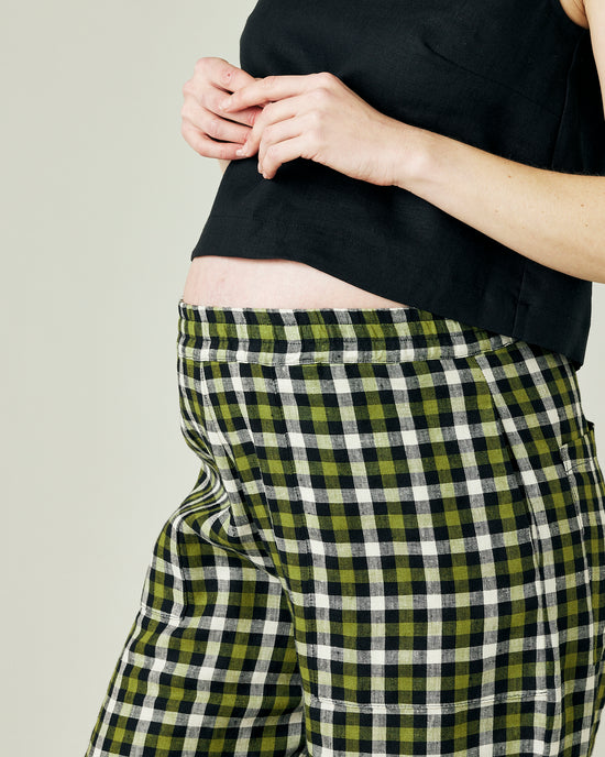 pregnant model wears olive black and ecru checked huxley trousers