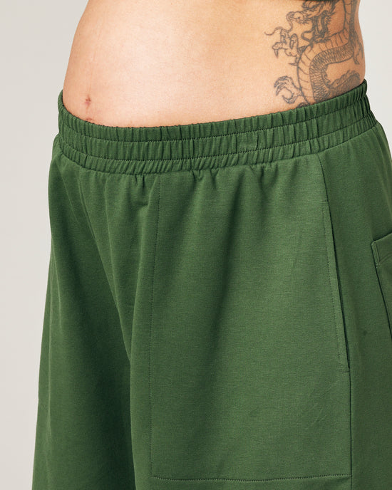 model wears kombu green jersey huxley trousers