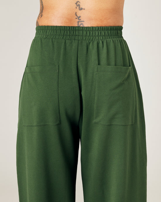 model wears kombu green jersey huxley trousers