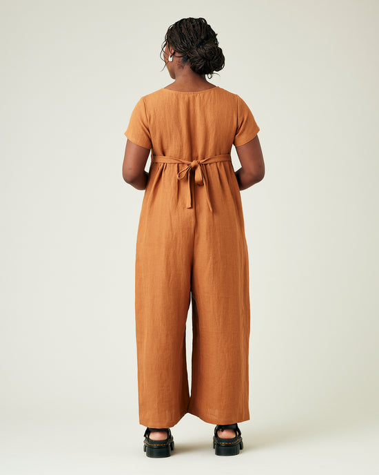 model wears rust linen sahara jumpsuit