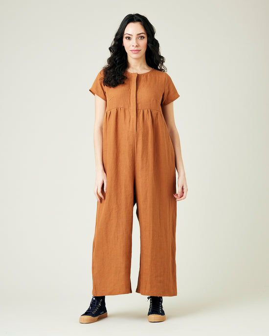 pregnant model wears rust linen sahara jumpsuit