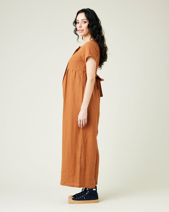 pregnant model wears rust linen sahara jumpsuit