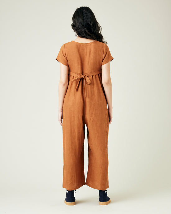 pregnant model wears rust linen sahara jumpsuit