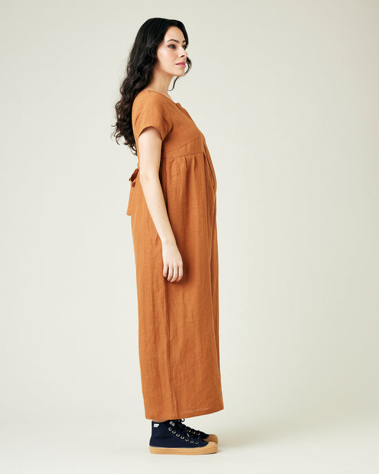 pregnant model wears rust linen sahara jumpsuit