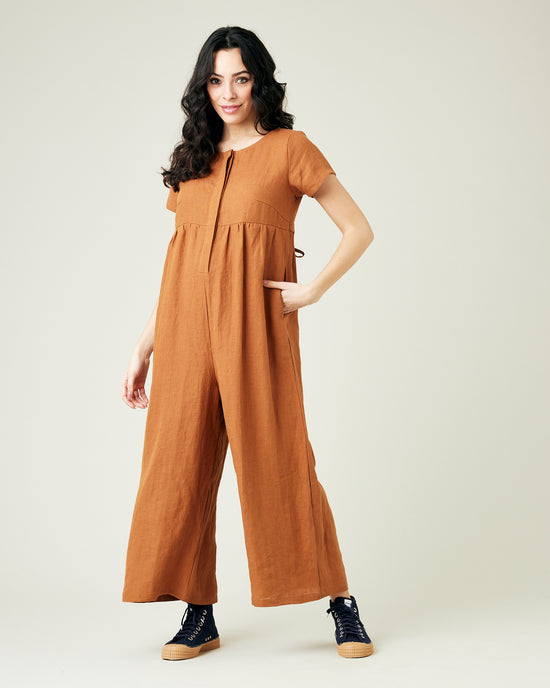 pregnant model wears rust linen sahara jumpsuit