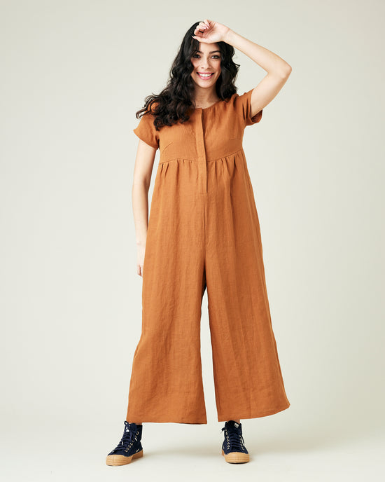 pregnant model wears rust linen sahara jumpsuit