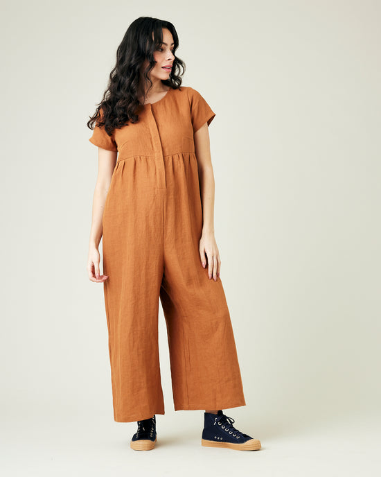 pregnant model wears rust linen sahara jumpsuit