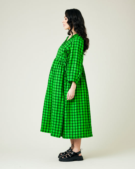 pregnant model wears green and black check linen isabel dress