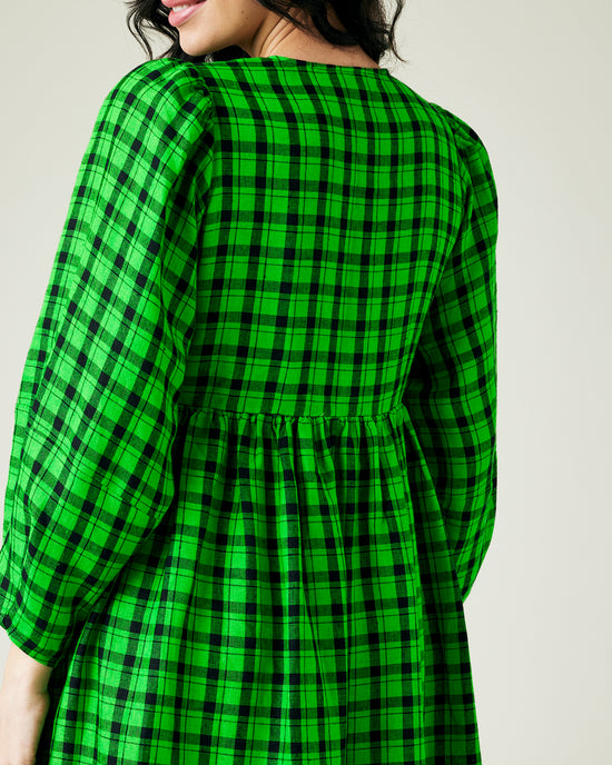 pregnant model wears green and black check linen isabel dress