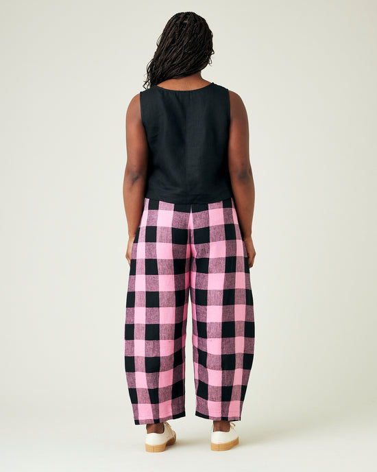 model wears daisy pink and black mega check linen trousers 