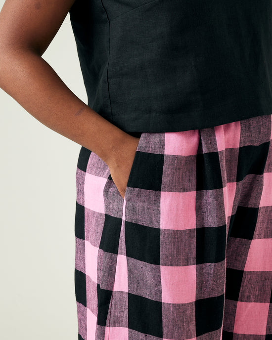 model wears daisy pink and black mega check linen trousers 