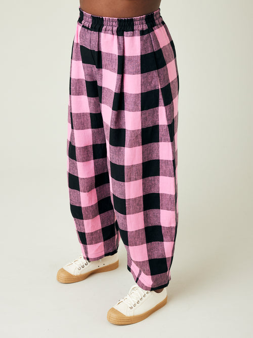 model wears daisy pink and black mega check linen trousers left