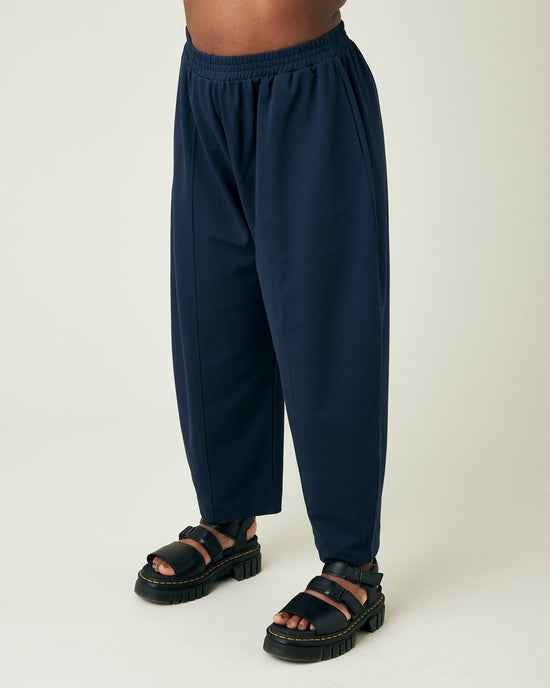 model wears navy jersey mabel trousers from the left side