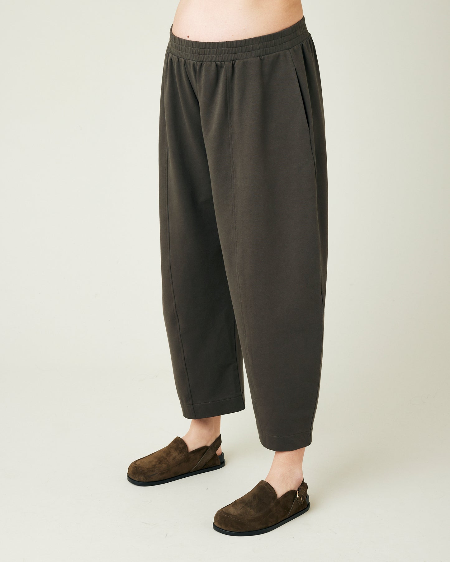 pregnant model wears espresso jersey mabel trousers from left side