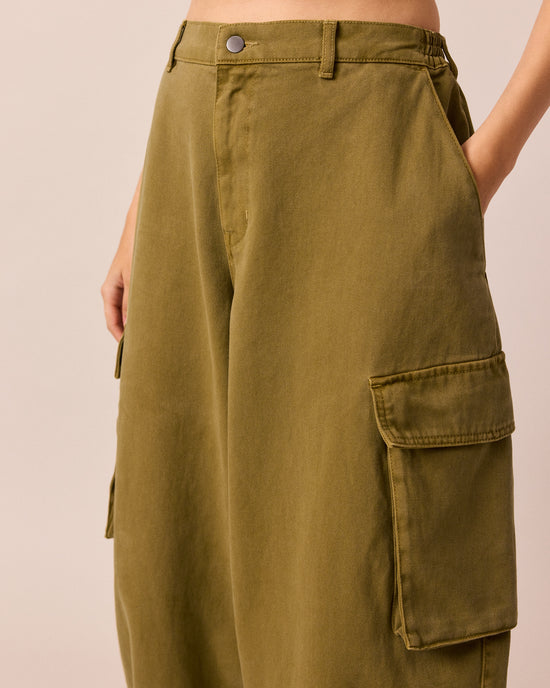 model wears claudie bronzed hay denim jeans right