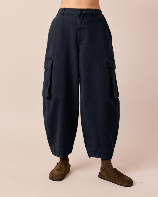 model wears claudie navy denim trousers front