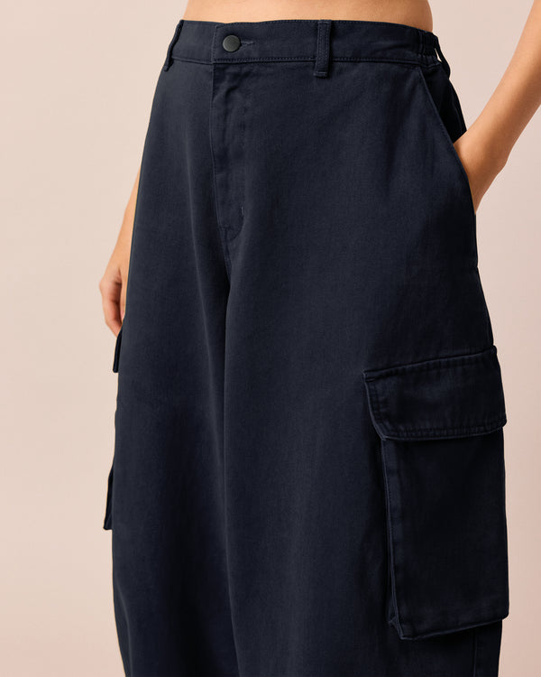 model wears claudie navy denim trousers right