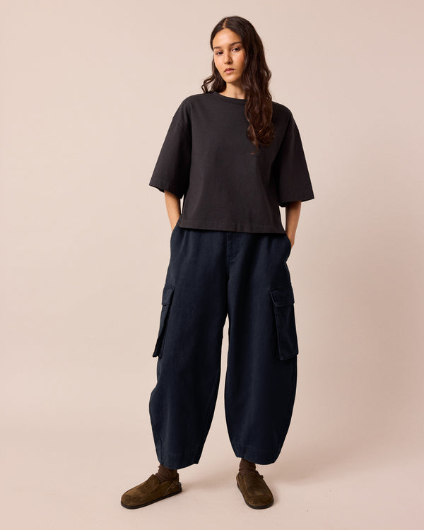 model wears claudie navy denim trousers back