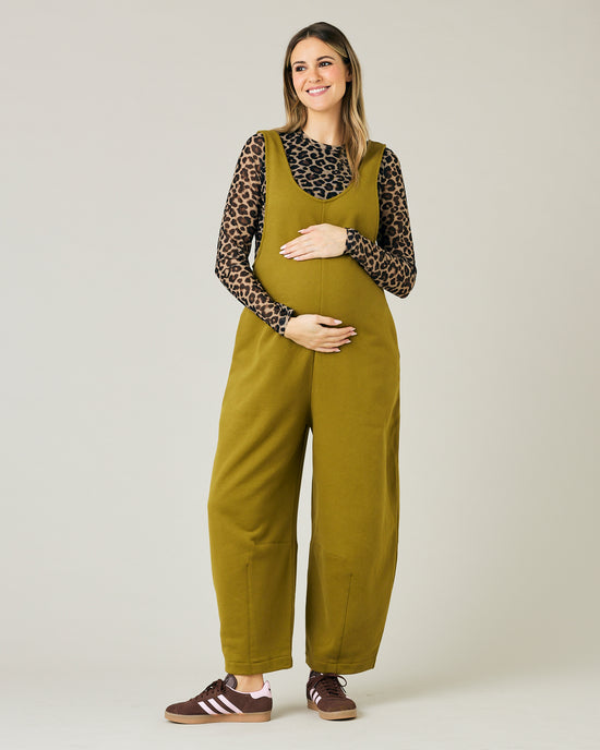 pregnant model wears golden olive jersey clover jumpsuit